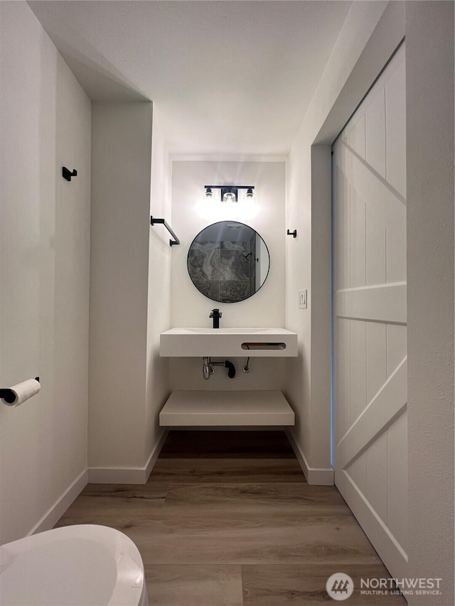 bathroom with baseboards and wood finished floors