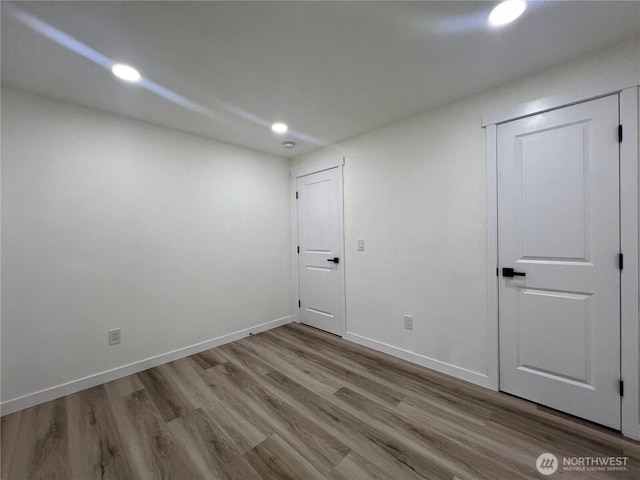 interior space featuring recessed lighting, baseboards, and wood finished floors