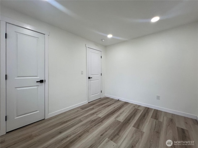 unfurnished bedroom with recessed lighting, baseboards, and wood finished floors