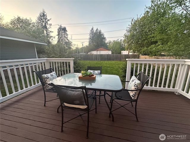 deck with a fenced backyard, outdoor dining area, and a lawn