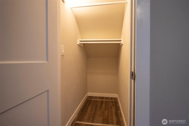 walk in closet with wood finished floors