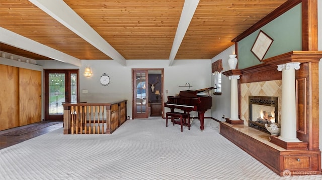 carpeted living area with baseboards, a high end fireplace, wood ceiling, and beamed ceiling