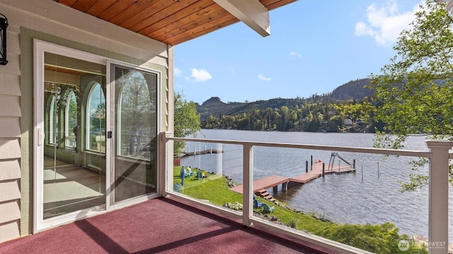 balcony with a boat dock and a water and mountain view