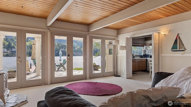 interior space with french doors, a water view, light carpet, and beamed ceiling