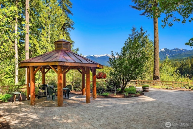 view of home's community featuring a gazebo, a mountain view, fence, and a patio