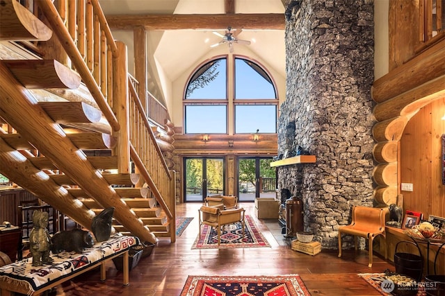 living area featuring beam ceiling, wood-type flooring, high vaulted ceiling, stairs, and a ceiling fan