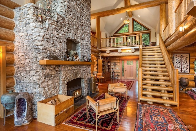living area with log walls, hardwood / wood-style flooring, high vaulted ceiling, and beam ceiling