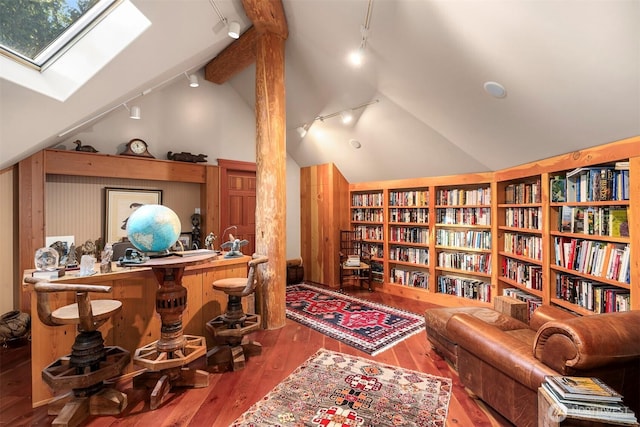 interior space with track lighting, lofted ceiling with skylight, and hardwood / wood-style flooring