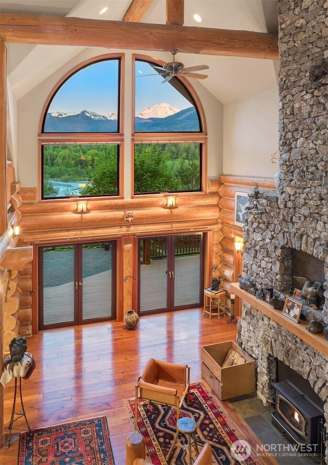 living room with rustic walls, plenty of natural light, french doors, and beam ceiling