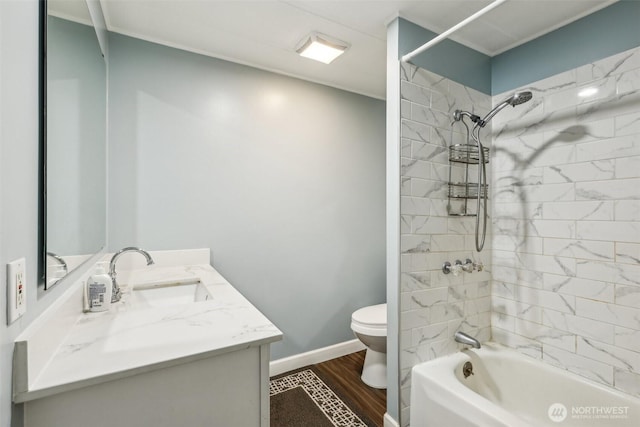 bathroom with wood finished floors, vanity, baseboards, toilet, and shower / bathtub combination