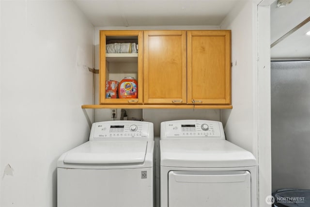 clothes washing area with cabinet space and washing machine and clothes dryer