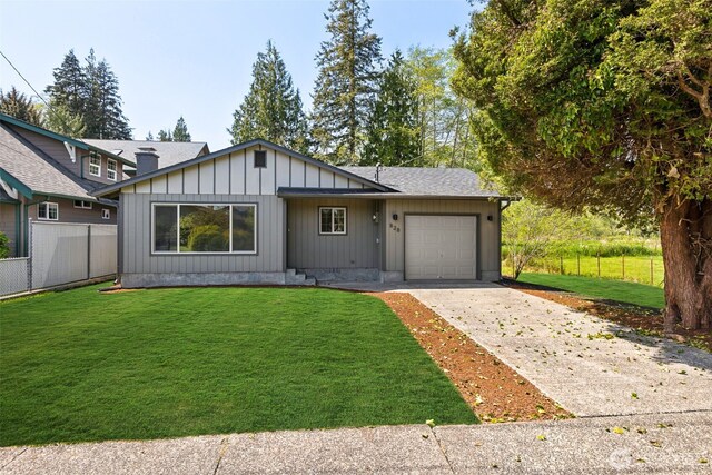 ranch-style house with fence, an attached garage, concrete driveway, and a front yard