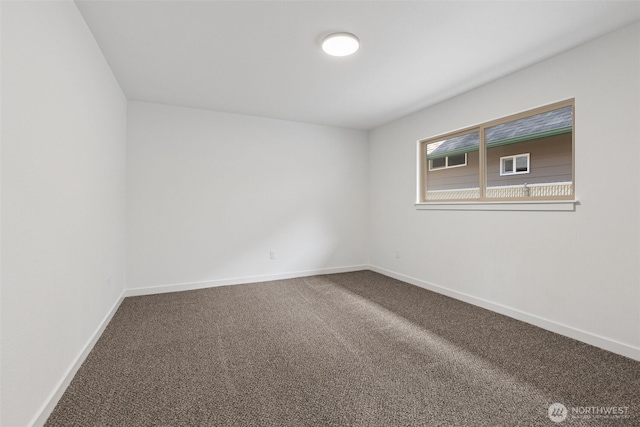 carpeted empty room featuring baseboards