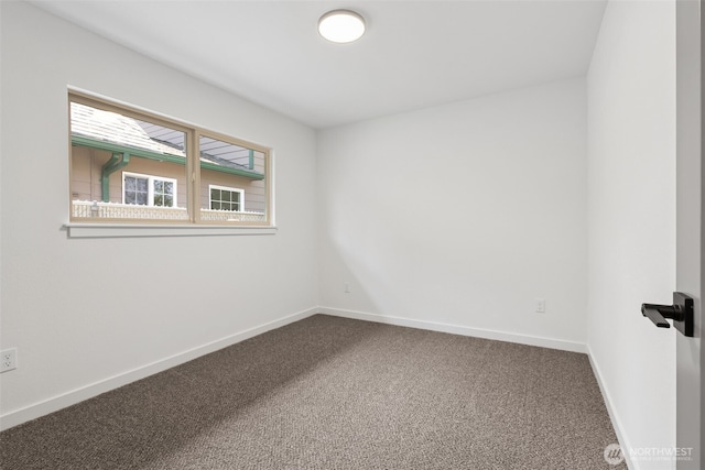 carpeted empty room featuring baseboards