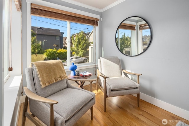 sitting room with wood finished floors, baseboards, and ornamental molding