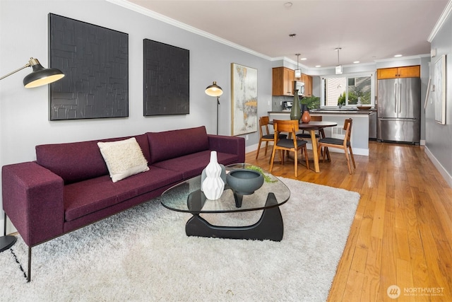living room featuring baseboards, ornamental molding, light wood finished floors, and recessed lighting
