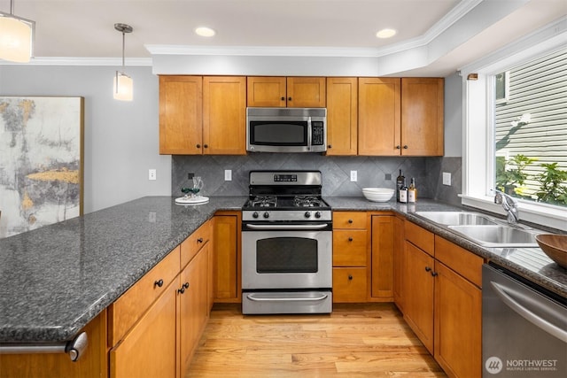 kitchen featuring brown cabinetry, ornamental molding, and stainless steel appliances
