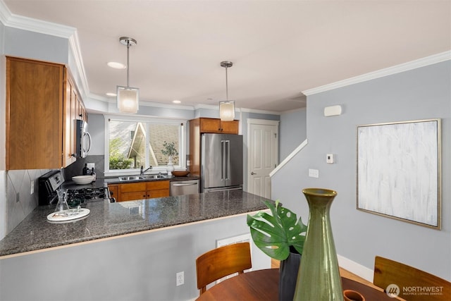 kitchen featuring decorative backsplash, a peninsula, brown cabinets, a sink, and stainless steel appliances