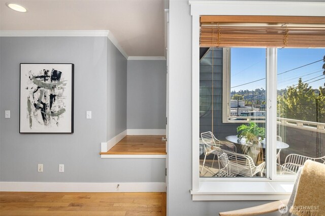 interior details featuring baseboards, ornamental molding, and wood finished floors