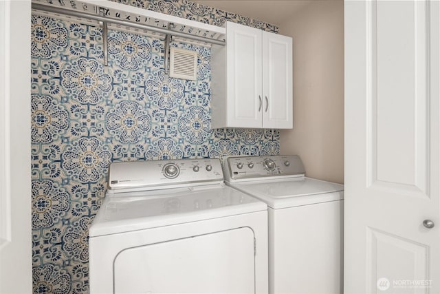 washroom with washer and clothes dryer and cabinet space