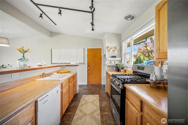 kitchen with a sink, light countertops, stone finish floor, stainless steel appliances, and lofted ceiling