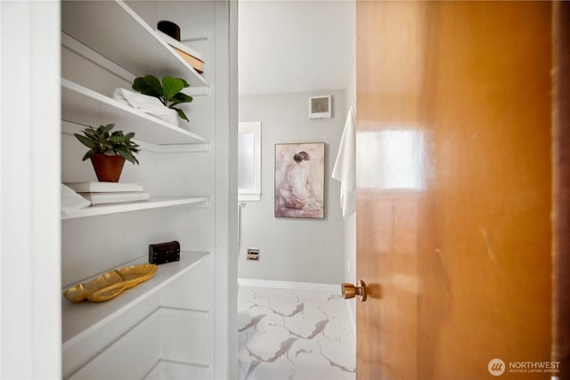 doorway with baseboards and marble finish floor