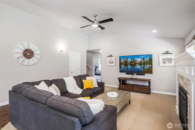 living room featuring baseboards, a glass covered fireplace, ceiling fan, and lofted ceiling