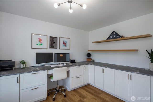 office with built in desk and light wood-style floors