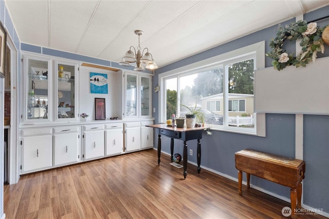 15713 81st St E Unit 135, Puyallup, WA 98372 - dining area featuring a chandelier, light wood-style floors, and baseboards