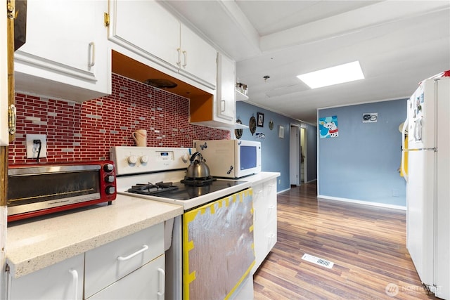15713 81st St E Unit 135, Puyallup, WA 98372 - kitchen with white appliances, white cabinets, light wood-style floors, and backsplash