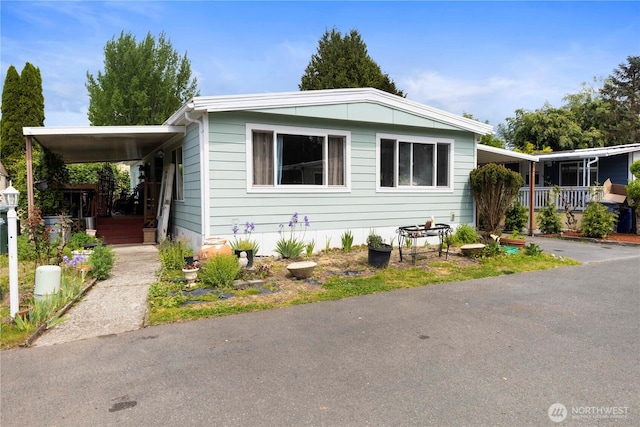 15713 81st St E Unit 135, Puyallup, WA 98372 - manufactured / mobile home with a carport, asphalt driveway, and a porch