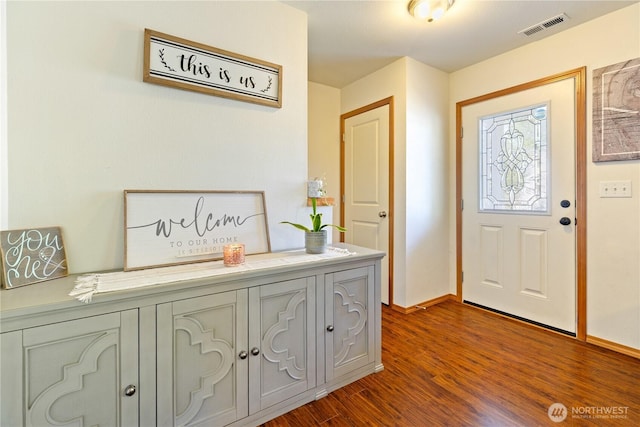 foyer entrance featuring dark wood finished floors and baseboards