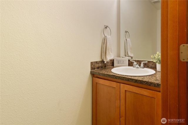 bathroom featuring vanity and tasteful backsplash