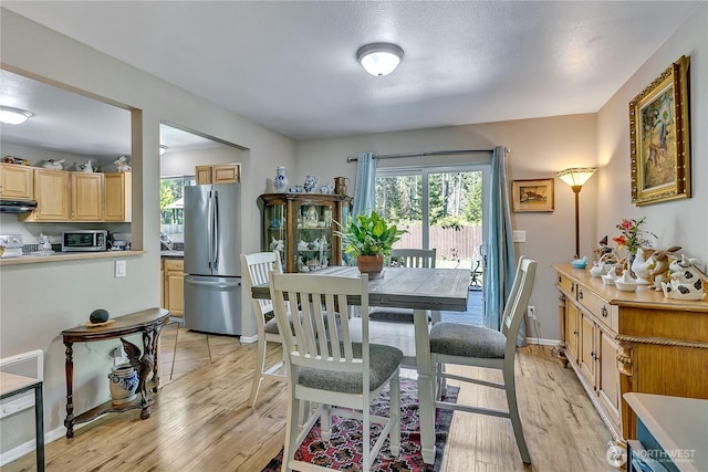 dining area featuring baseboards and light wood-style flooring
