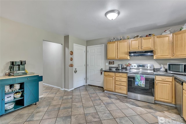 kitchen with light brown cabinetry, dark countertops, baseboards, under cabinet range hood, and stainless steel appliances