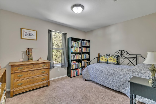 bedroom featuring baseboards and light carpet
