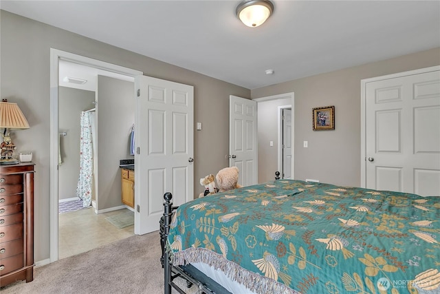 bedroom featuring baseboards, light colored carpet, light tile patterned floors, and ensuite bath