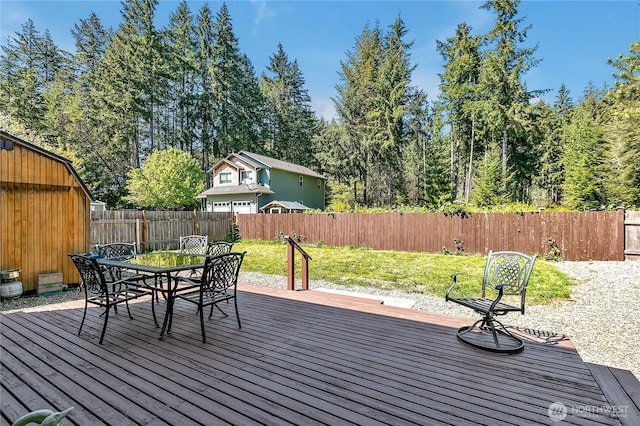 deck featuring a lawn, outdoor dining area, and a fenced backyard