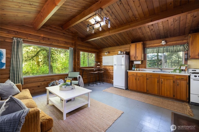 living area featuring vaulted ceiling with beams, wood walls, light floors, and wood ceiling