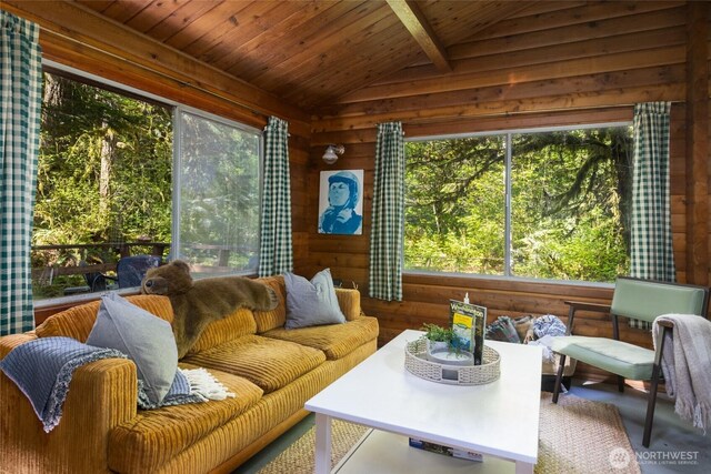 sunroom / solarium featuring a healthy amount of sunlight and beamed ceiling