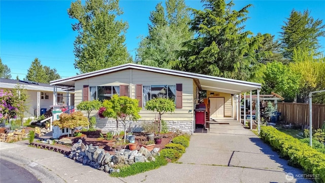 view of front of home featuring driveway, fence, and an attached carport