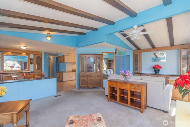 carpeted living room featuring a ceiling fan, visible vents, and lofted ceiling with beams