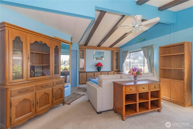 living area with light colored carpet, a ceiling fan, and vaulted ceiling with beams