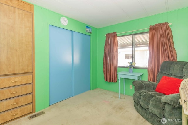 living area featuring elevator, visible vents, and carpet