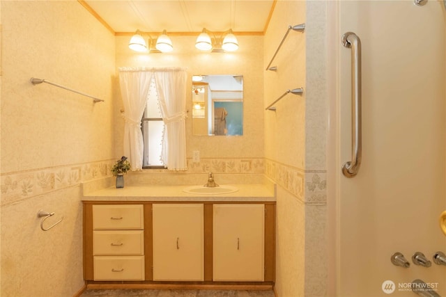 full bathroom featuring walk in shower, vanity, and crown molding