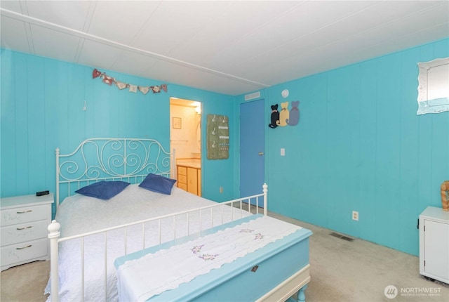 bedroom with carpet, ensuite bath, and visible vents