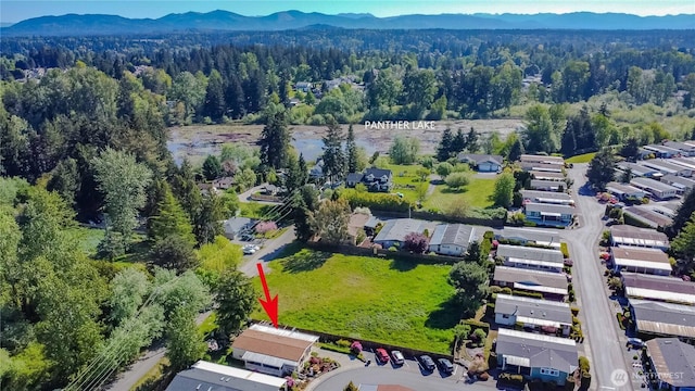 drone / aerial view featuring a wooded view, a mountain view, and a residential view