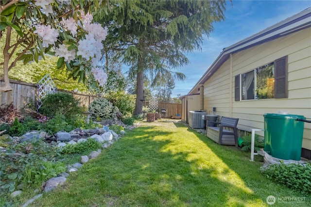 view of yard featuring a fenced backyard and central AC