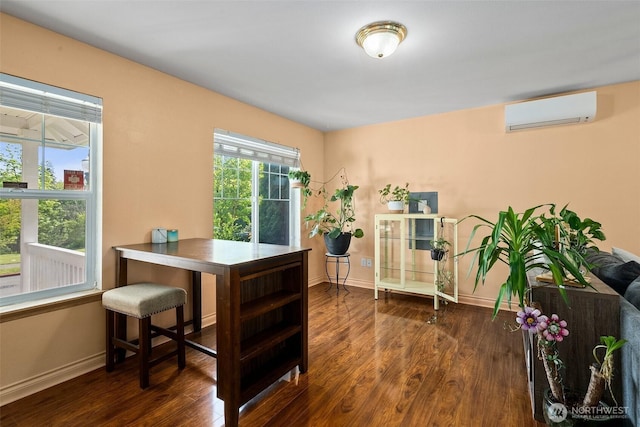 office area with baseboards, a wall mounted air conditioner, and dark wood-style flooring