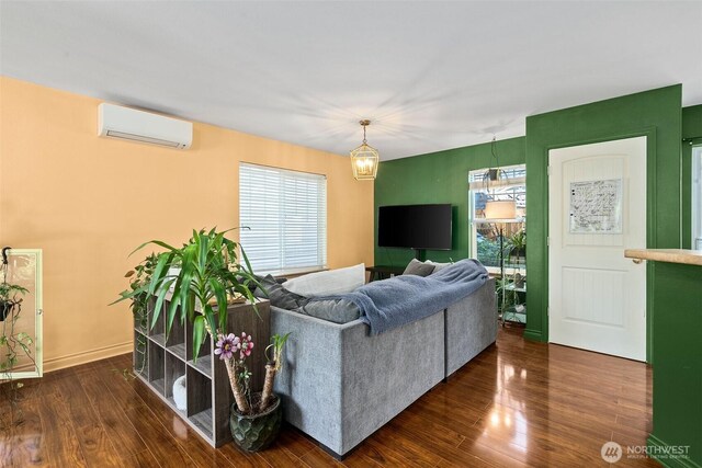living room with an AC wall unit and dark wood-style floors
